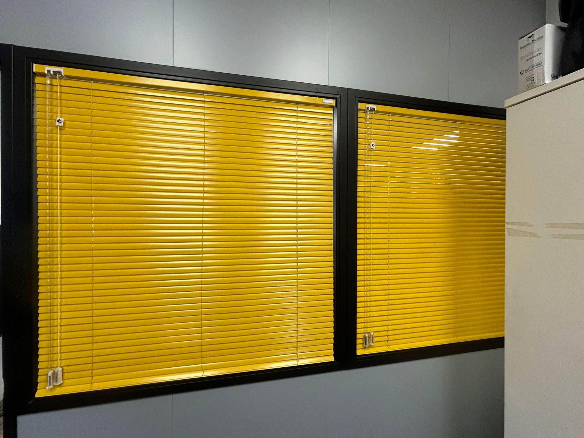 Instalación de cortinas venecianas de aluminio con lamas de 25mm, color 074 Lemon Peel, en oficinas de Barcelona