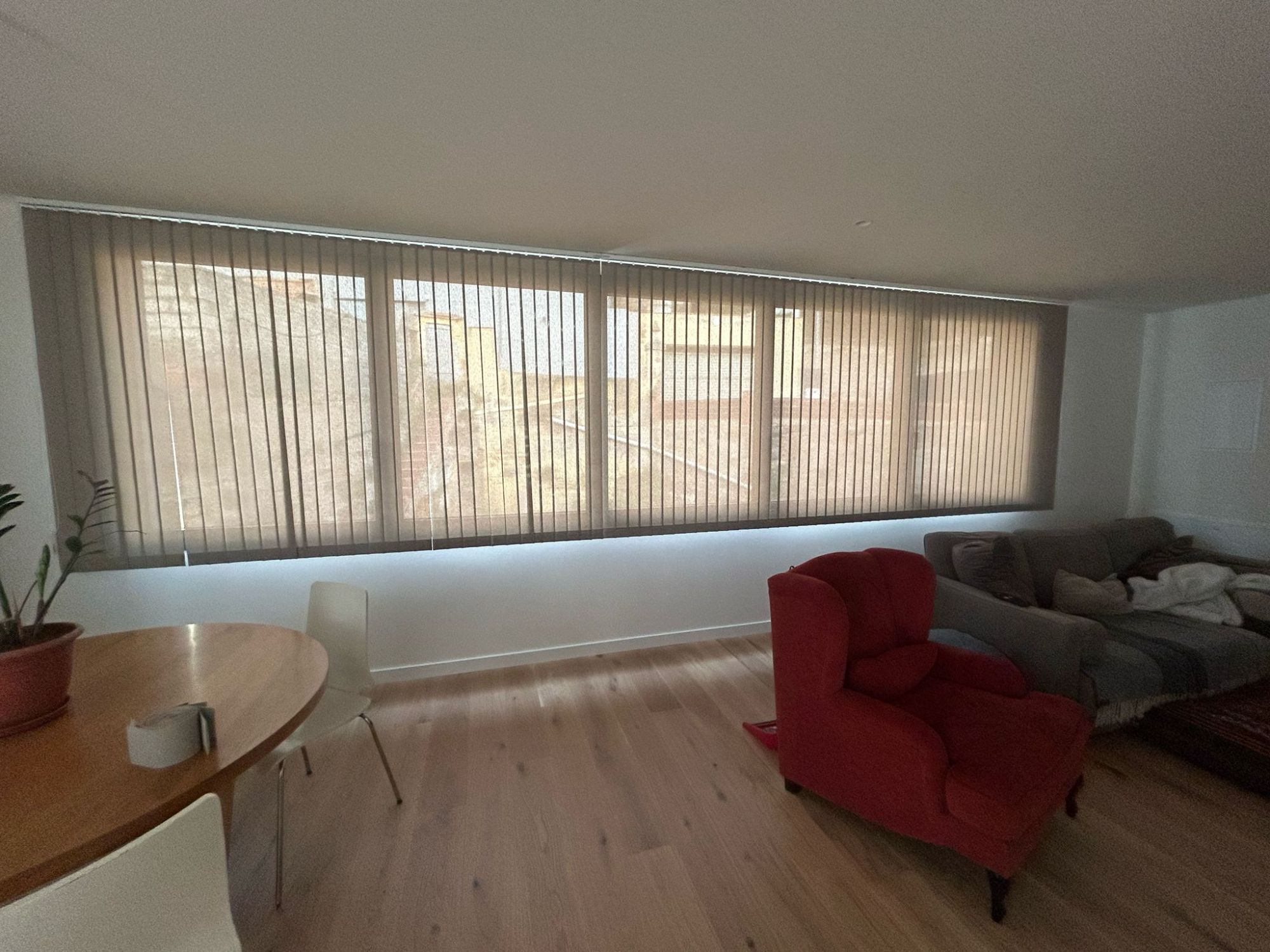 Instalación de cortinas verticales con lamas de 89mm y tejido técnico screen, referencia PS351 abertura del 1% y color blanco, en vivienda de Barcelona