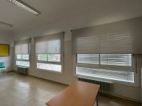 Instalación de cortinas enrollables con tejido técnico screen, referencia 420P abertura del 1% y color White/Pearl, en escuela de Viladecans
