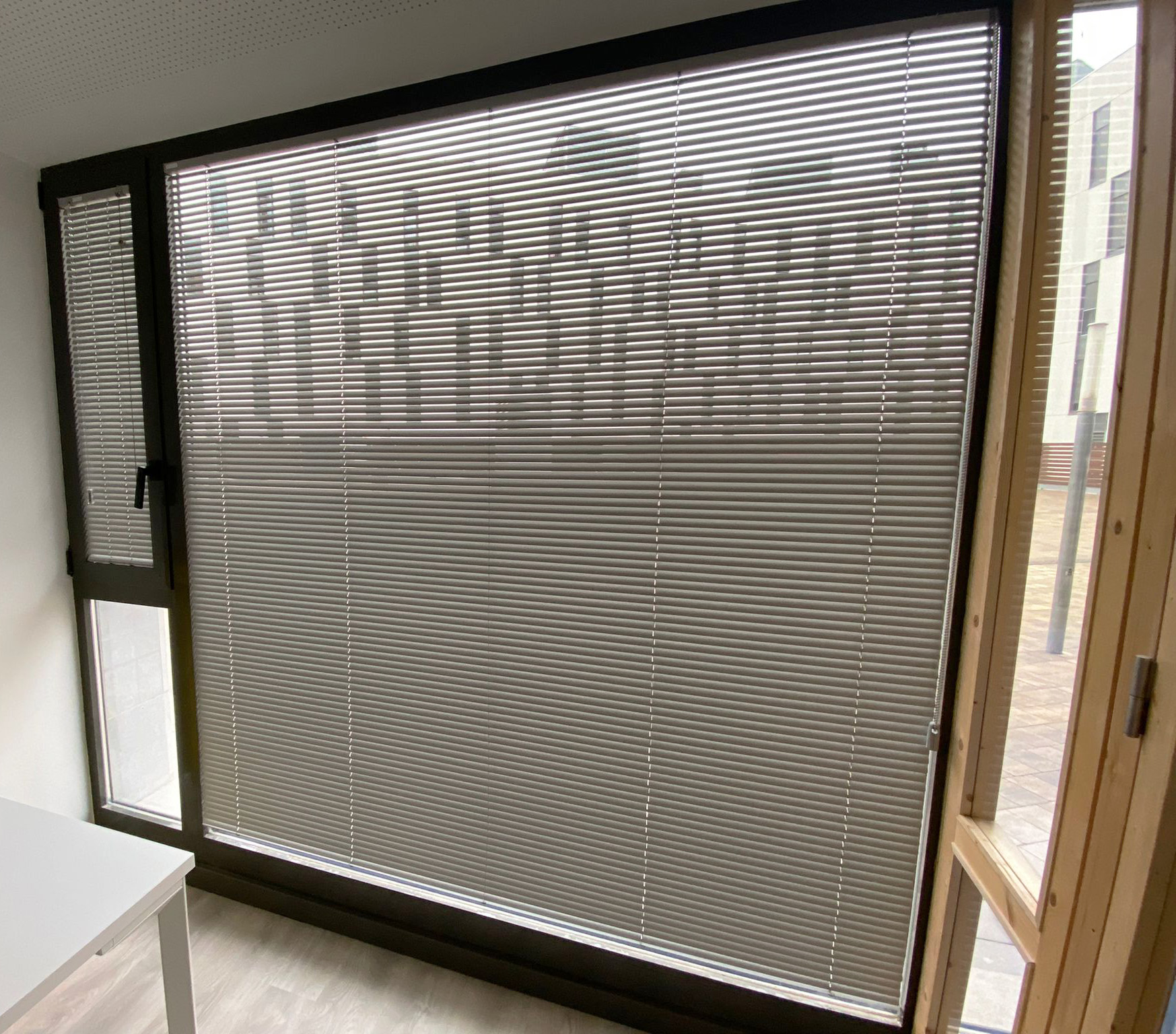 Cortinas venecianas de aluminio instaladas en ventanas de despacho en Barcelona